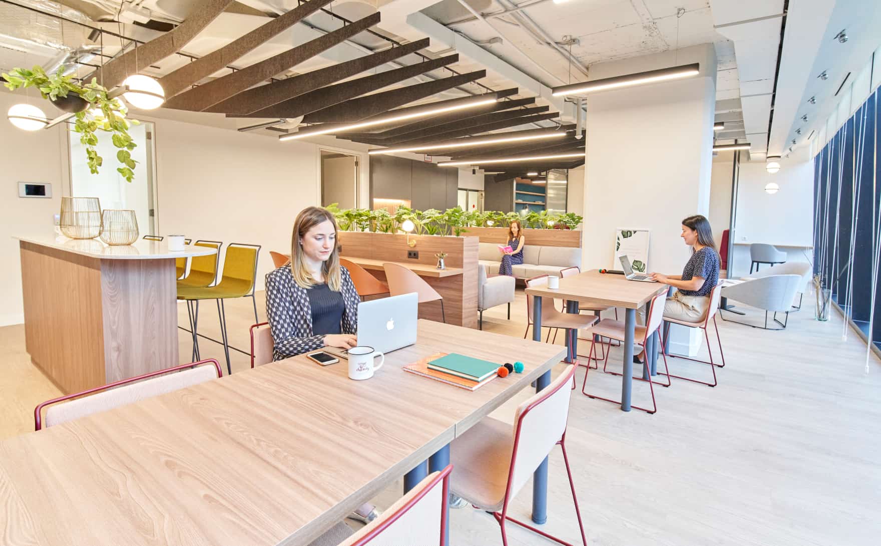 Personas trabajando en una oficina híbrida contentos